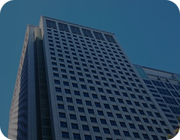 日本现代办公摩天大楼的低角度视图，配有类似网格的窗户，背景是清澈的蓝天。