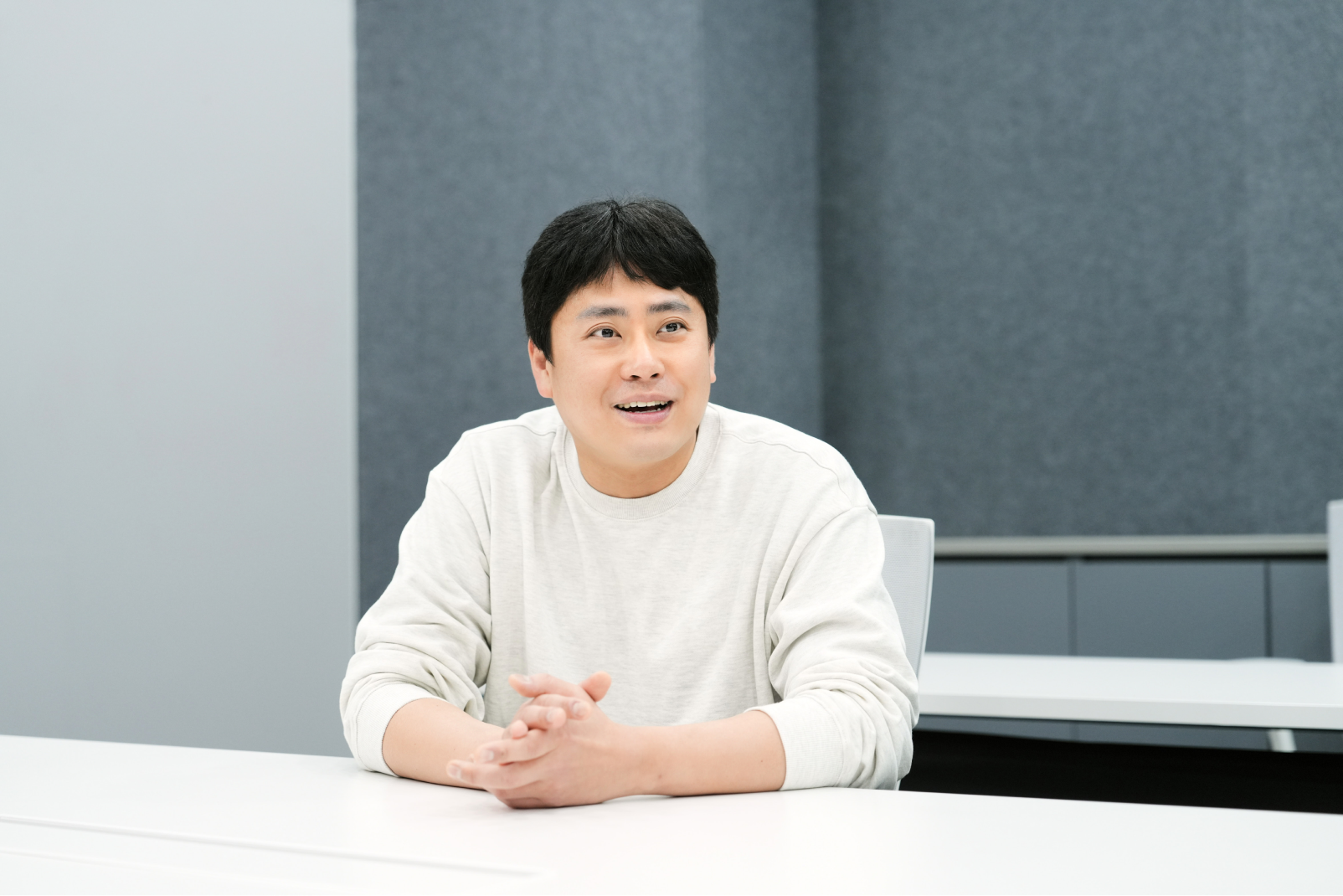 Sunki Yun from the Solution Product & Development Team speaking during an interview, seated at a conference table with a relaxed and engaged expression.