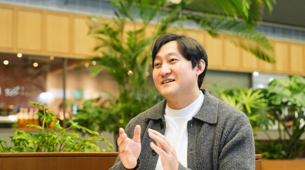 安全与电力产品开发团队的金智哲在轻松的室内环境中带着温暖的微笑和富有表现力的手势发言