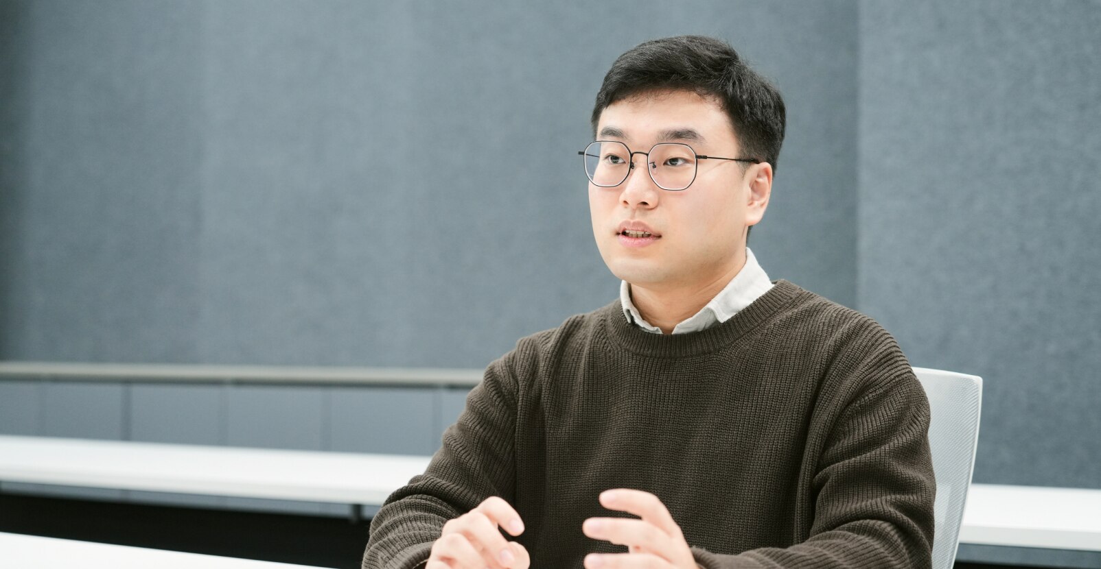 An engineer from the Memory Product Planning Team is speaking and gesturing during a meeting.