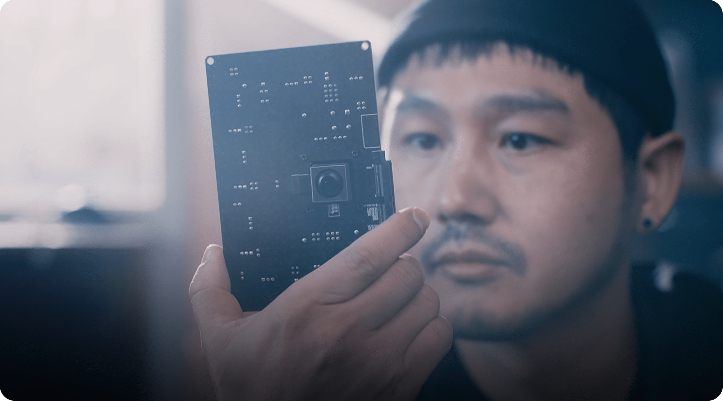 男人正在看 200 兆像素的ISOCell 图像传感器。