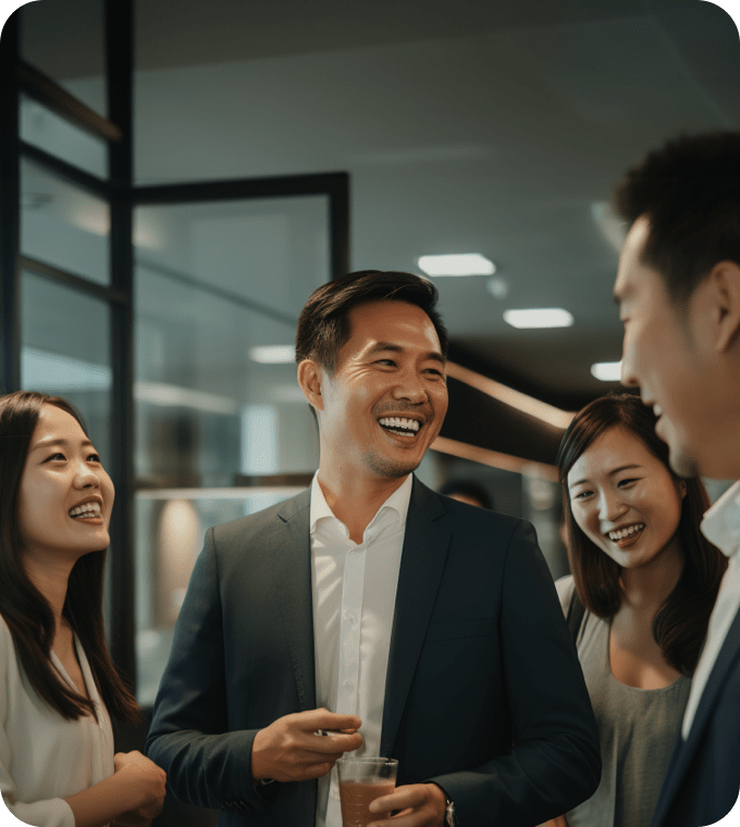 图为在明亮的办公室里，身着商务服装的人们一起笑着交谈。