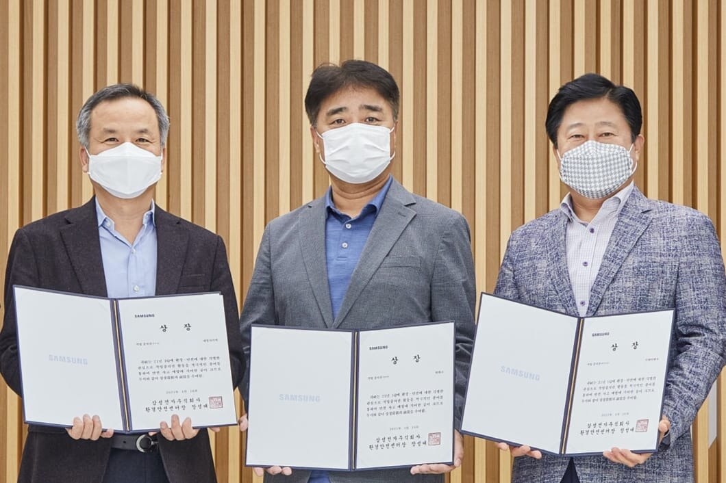 三位获得卓越合作伙伴奖的首席执行官手持证书站立。