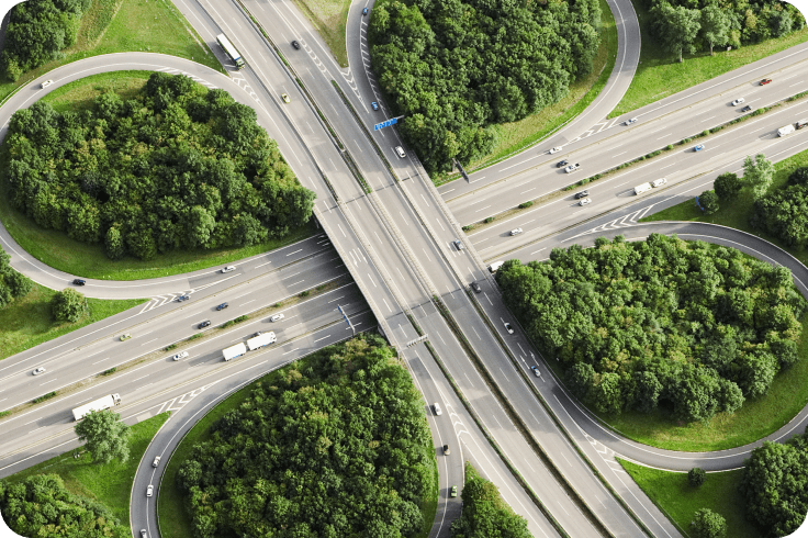 一张绿林环绕的高速公路交叉口的航拍照片.