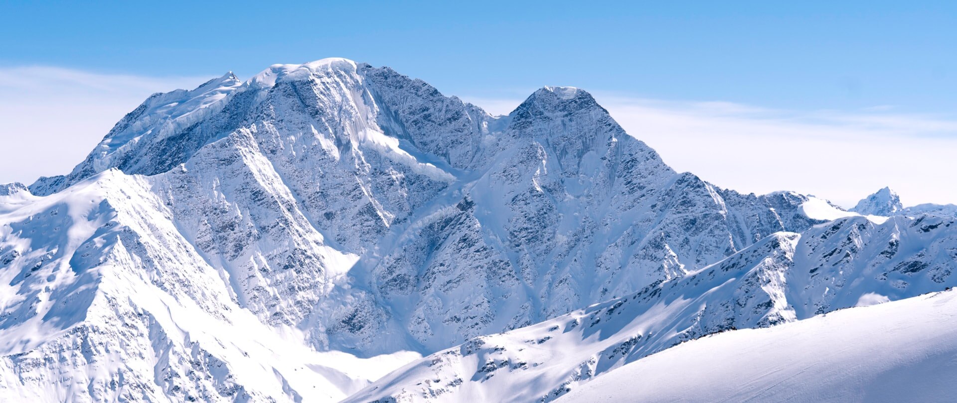 高海拔的山峰上覆盖着大量的积雪，使得气温显得寒冷。