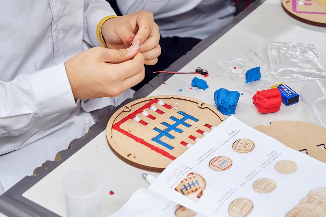 一位穿着校服的学生正在组装半导体科学课堂套件。