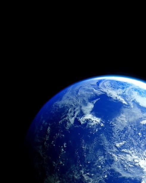 地球在黑暗的宇宙中散发出蓝色光芒。